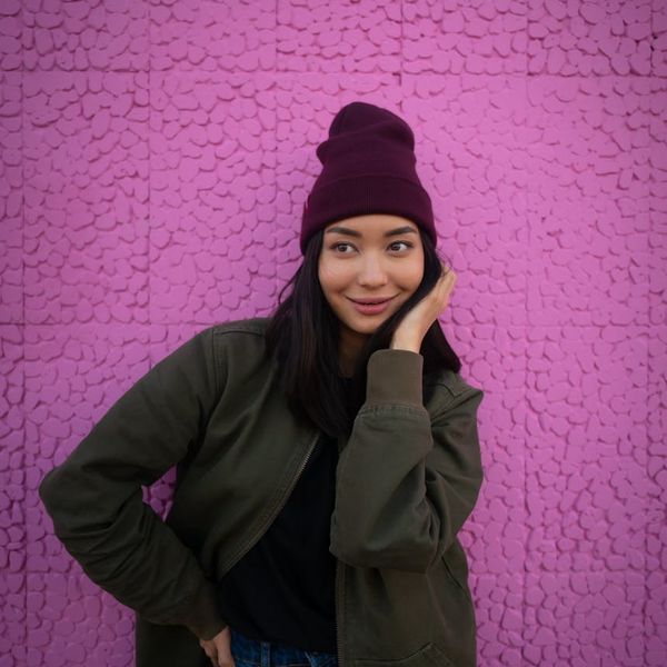 Person smiling and looking energetic against a vibrant background.